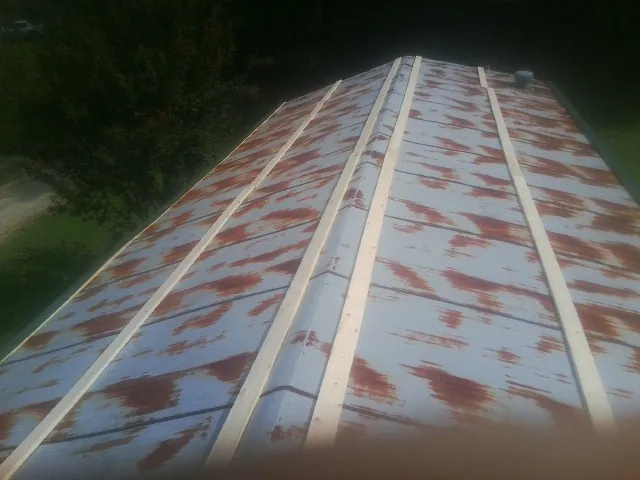 Rusted metal roof panels with new wood purlins before replacement — Storm Damage Roof Repair in Dawson by Roofing Brothers